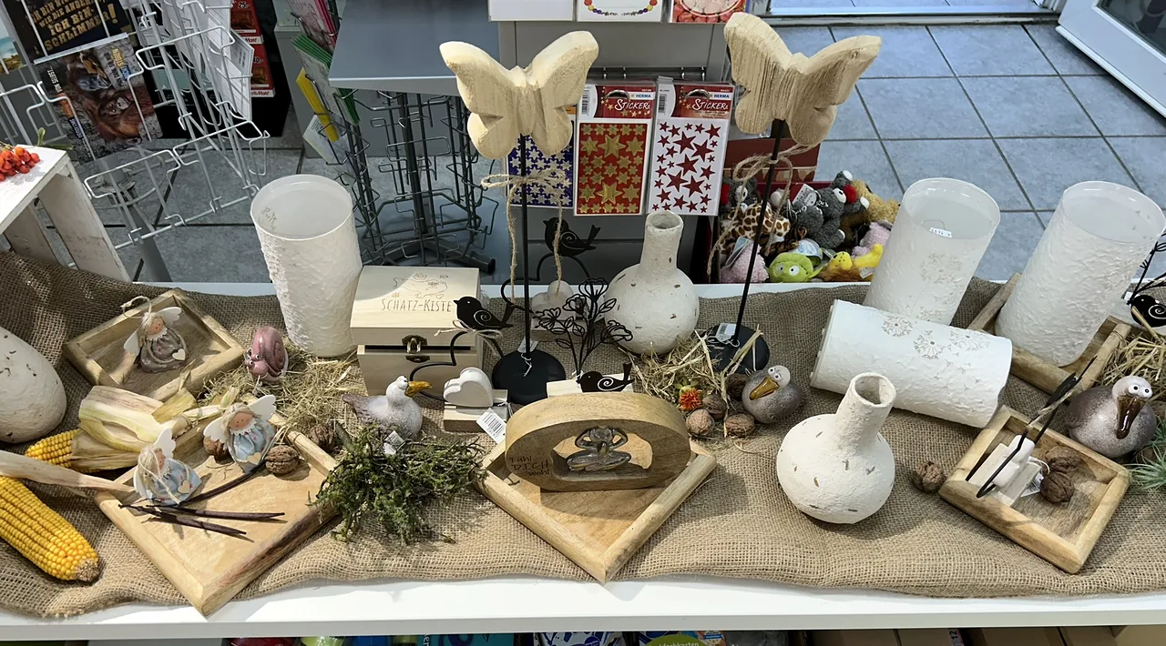 Dekotisch mit weißen Vasen, Holztabletts, Schmetterlingen und kleinen Figuren