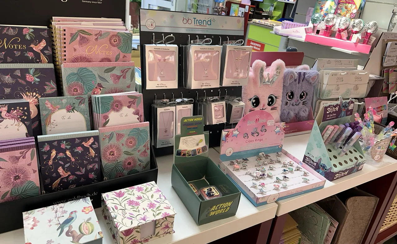 Gemusterte Notizbücher, Schmucksets und kleine Geschenkartikel auf einem Tisch