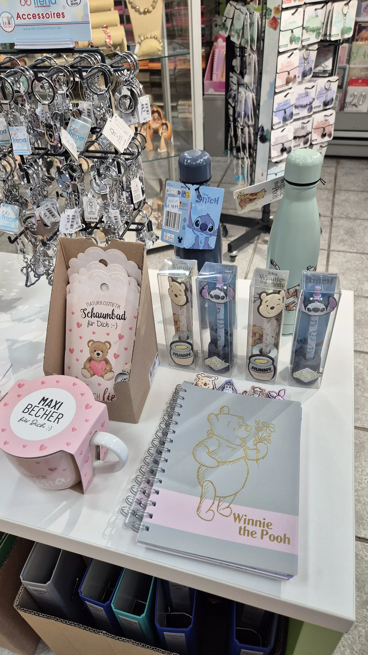 Tassen, Trinkflaschen und kleine Notizbücher auf dem Geschenktisch