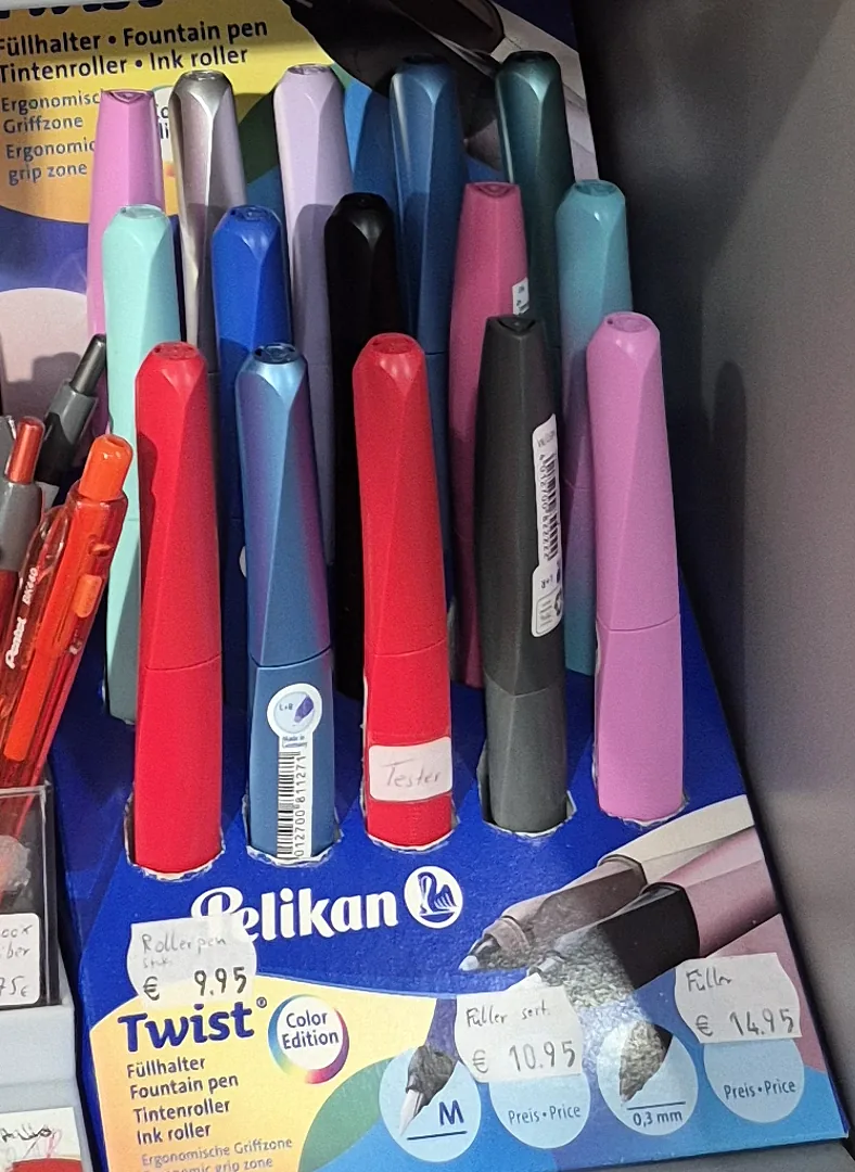 Farbige Füller und Tintenroller im unteren Regalbereich