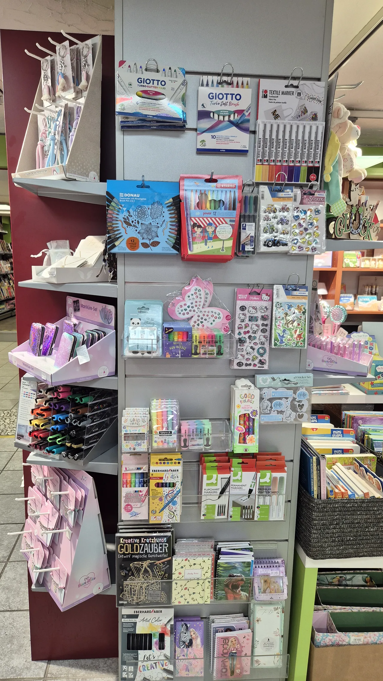 Regal mit Kreativmarkern, Stickern und kleinen Notizbüchern